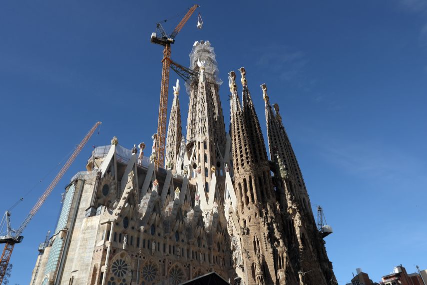 Una grúa levanta la última pieza de la cruz de 17 metros de altura y 13,5 metros de ancho que completa la Torre de Jesucristo de la Sagrada Familia en Barcelona el 20 de febrero de 2026.