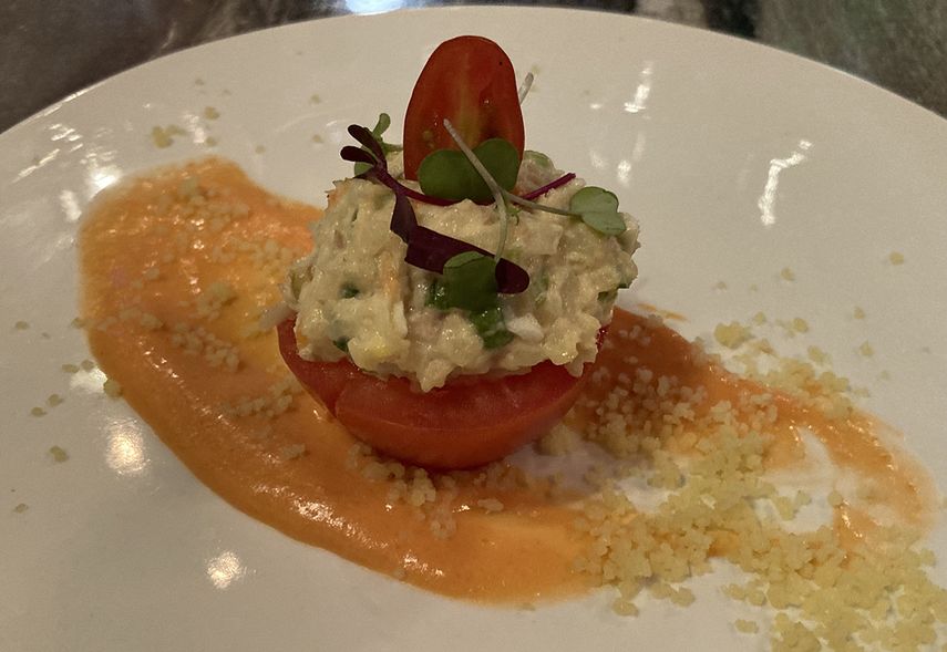 Tomate relleno de ensaladilla rusa con patata, mayonesa, aceitunas, verduras y tuna, sobre espuma de salmorejo cordobés.
