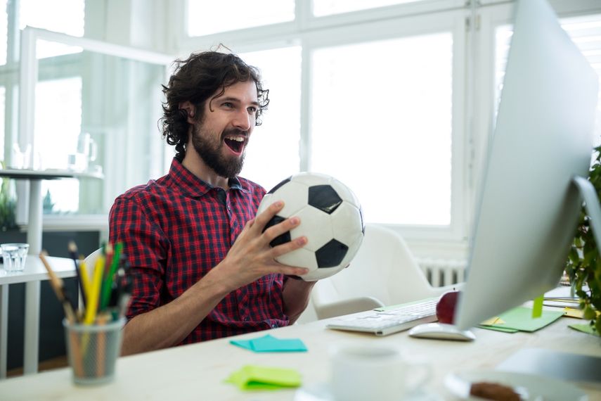 Hombre animando mientras ve un partido de fútbol