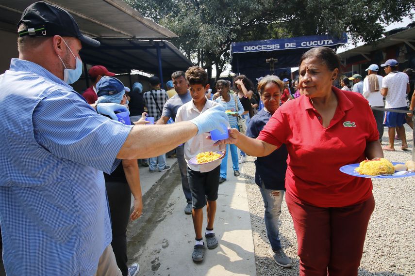 Un hombre ofrece comida a una mujer este martes en un albergue de la de la iglesia católica donde se atiende a ciudadanos venezolanos, en la ciudad de Cúcuta (Colombia). 