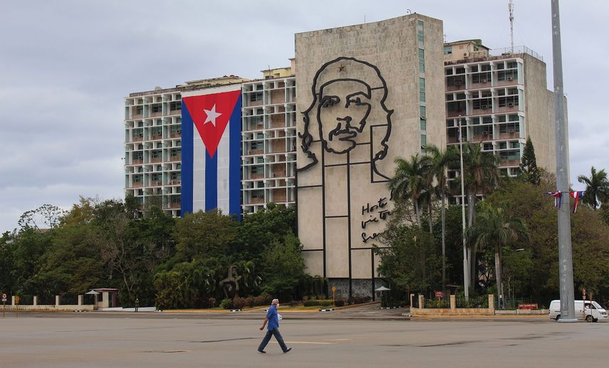 Un hombre usa una mascarilla facial mientras camina frente a un edificio gubernamental en La Habana, Cuba.