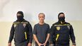 Esta fotografía, difundida por la Fiscalía General de Venezuela el 9 de abril de 2024, muestra al exministro de Petróleo venezolano Tareck El Aissami (C) escoltado por miembros de la Policía Nacional Anticorrupción tras su arresto en Caracas.