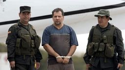 Policías escoltan al narcotraficante colombiano Daniel Rendón-Herrera, alias Don Mario, en un aeropuerto en Bogotá, Colombia, el 15 de abril del 2009.&nbsp;