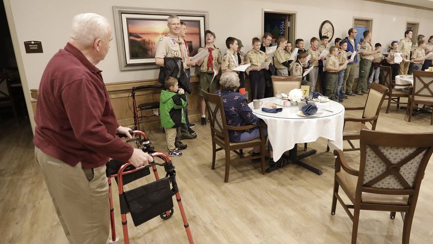 En esta foto del 12 de diciembre de 2019, un grupo de Boy Scouts de Kaysville, Utah, entona canciones de Navidad para un grupo de ancianos.