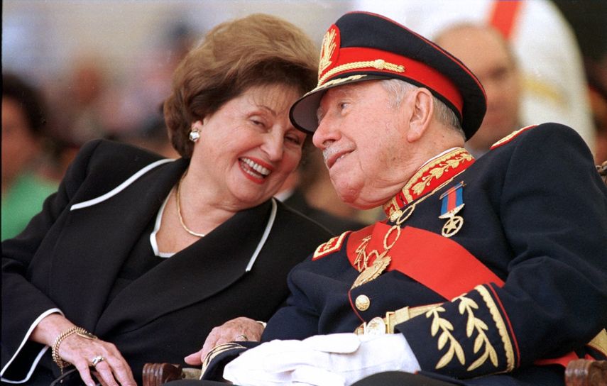 En esta foto de archivo tomada el 10 de marzo de 1998, el ex dictador chileno (1973-90) general Augusto Pinochet (der.) Escucha a su esposa Lucía Hiriart durante la ceremonia de retiro del mando del ejército en la Academia Militar de Santiago.