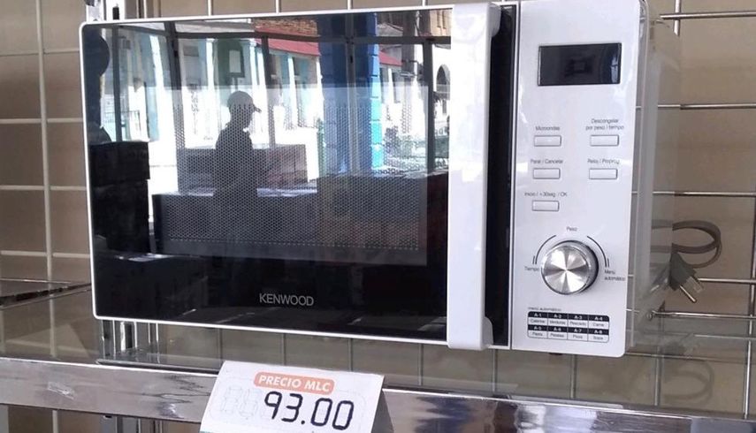 Un cliente reflejado en la puerta de un horno microondas en la tienda La Isla, de Mayar&iacute;, Holgu&iacute;n.