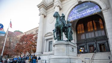 La gente ingresa al Museo Americano de Historia Natural frente a una controvertida estatua de Theodore Roosevelt a caballo con un nativo americano de un lado y un hombre africano del otro en la ciudad de Nueva York el jueves, 25 de noviembre de 2021.&nbsp;