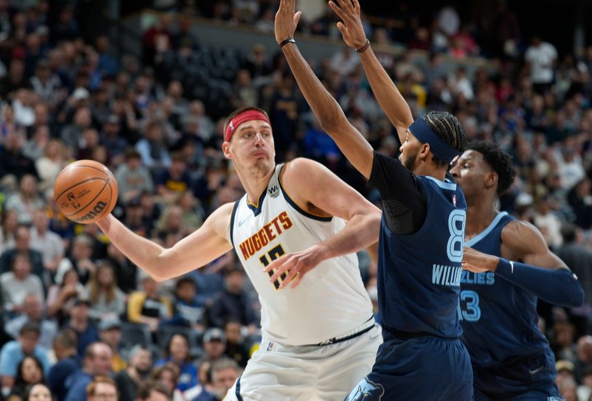 El pívot de los Nuggets de Denver Nikola Jokic busca pasar el balón mientras lo defiende el base de los Grizzlies de Memphis Ziaire Williams y el alero Jaren Jackson Jr. El serbio podría ser elegido como el MVP de la NBA en la temporada 2021 - 22