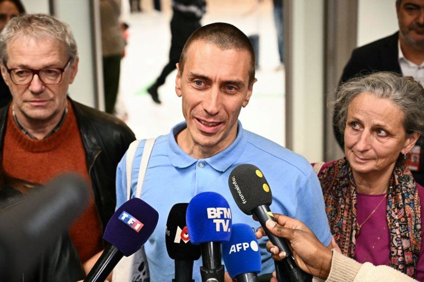 El ciudadano francés Camilo Castro, que estuvo detenido en Venezuela desde finales de junio, habla con la prensa, flanqueado por su padrastro Yves Guibert y su madre Helene Boursier, a su llegada al aeropuerto de Orly, en las afueras de París, tras su liberación el 16 de noviembre de 2025.