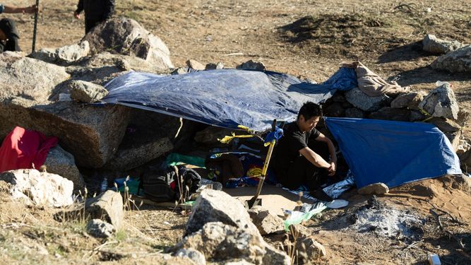 Un migrante chino se sienta frente a su tienda de campaña en un campamento para migrantes del lado estadounidense del muro fronterizo que separa a México de Estados Unidos en Jacumba, California, el 6 de diciembre de 2023.