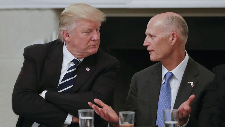 El presidente Donald Trump y el gobernador Rick Scott conversan durante un encuentro en la Casa Blanca.