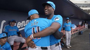 Jesús Sánchez, de los Marlins de Miami, abraza al entrenador de primera base Jon Jay (11) antes del inicio de un partido de béisbol de entrenamiento de primavera contra los Astros de Houston el domingo 10 de marzo de 2024 en West Palm Beach, Florida 
