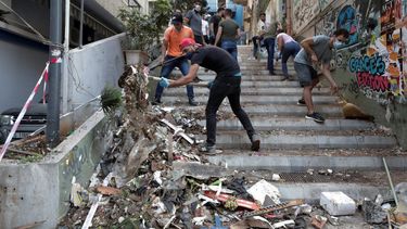 Personas remueven escombros de una calle tras la explosi&oacute;n en Beirut, L&iacute;bano, mi&eacute;rcoles 5 de agosto de 2020.&nbsp;