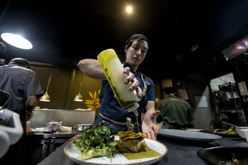 Un chef decora un platillo en el restaurante Sikwa, que basa su menú en la cocina tradicional de los pueblos indígenas de Costa Rica para mantener viva la cultura gastronómica indígena en San José, el 14 de febrero de 2023.