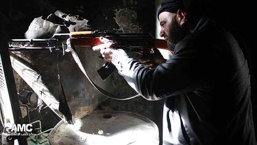 Un combatiente del Ejército Sirio Libre apunta su AK-47 en Alepo, Siria. (Foto AP/Aleppo Media Center AMC, archivo)