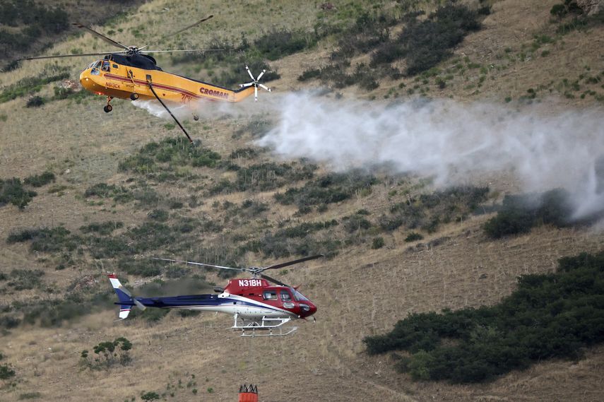 Dos helicópteros combaten un incendio en Springville, Utah, el lunes 1 de agosto de 2022.&nbsp;