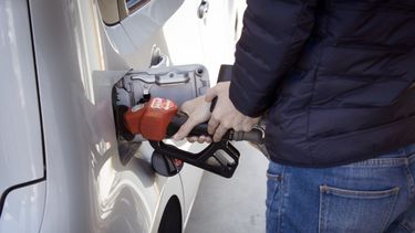 Un conductor echa combustible a su auto.