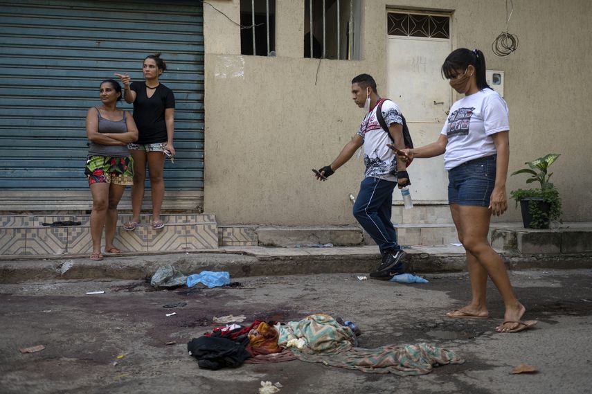 Residentes de acarezinho toman fotografías de pertenencias cubiertas de sangre de personas asesinadas durante un operativo policial contra presuntos narcotraficantes en la favela Jacarezinho en Río de Janeiro, Brasil, el 6 de mayo de 2021.