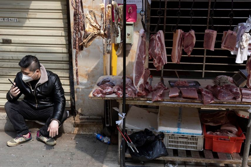Un vendedor espera&nbsp;a clientes en un estante cerca de un mercado aún parcialmente cerrado por el brote de coronavirus en Wuhan, en el centro de China.&nbsp;