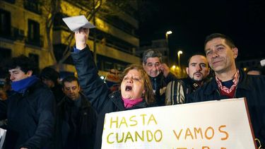 Manifestantes muestran pancartas durante una concentración en la que varios centenares de asistentes han protestado contra la corrupción en la sede del PP en Madrid. EFE