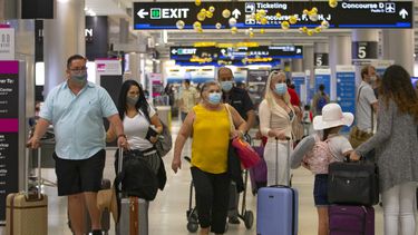 Viajeros con mascarillas caminan el domingo 22 de noviembre por el Aeropuerto Internacional de Miami. &nbsp;