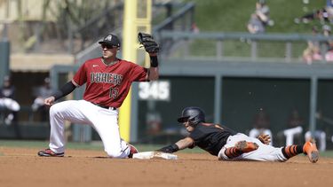 En esta foto de archivo del 2 de marzo de 2020, Nick Ahmed, de los Diamondbacks de Arizona, pone out al hondure&ntilde;o Mauricio Dub&oacute;n de los Gigantes de San Francisco, en un juego de pretemporada disputado en Scottsdale