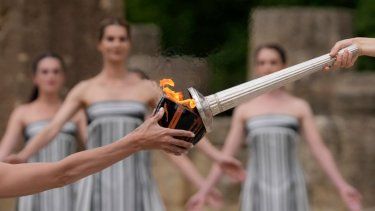 La actriz Mary Mina, que interpreta a una sacerdotisa, a la derecha, enciende una antorcha durante la ceremonia oficial para los Juegos Olímpicos de París, en la Antigua Olimpia, Grecia, el martes 16 de abril de 2024.&nbsp;