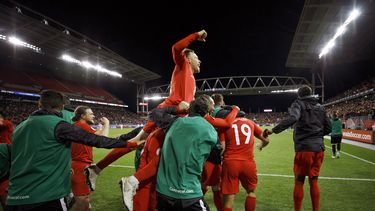 Scott Artfield, (arriba), volante de Canad&aacute;, festeja con sus compa&ntilde;eros un tanto de Lucas Cavallini (19), en un partido de la Liga de Naciones de la Concacaf ante Estados Unidos, el martes 15 de octubre de 2019 en Toronto