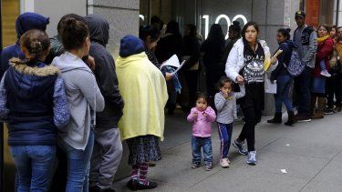Cientos de personas hacen cola frente a una oficina del servicio de inmigración en San Francisco.