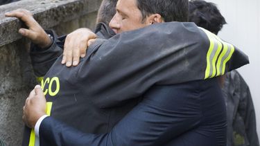 Fotografía facilitada por el Palacio Chigi del gobierno italiano que muestra al primer ministro Matteo Renzi (d) abranzando a los voluntarios que trabajan en las labores de rescate tras el terremoto en la localidad de Amatrice, en el centro de Italia
