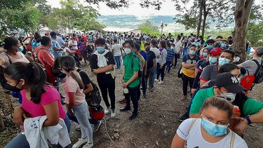 Hondureños y nicaragüenses hacen cola para vacunarse con las vacunas Pfizer-BioNTech y Moderna contra la enfermedad del nuevo coronavirus, COVID-19, en Guasaule, Honduras, en la frontera entre los dos países.