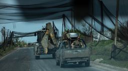 En esta fotografía distribuida el 7 de mayo de 2026 y publicada el 8 de mayo de 2026 por el servicio de prensa de la 93.ª Brigada Mecanizada Separada de Kholodnyi Yar de las Fuerzas Terrestres de Ucrania, militares ucranianos del batallón Cuervo Negro viajan en vehículos por una carretera cubierta con una red para proteger los vehículos de los ataques de drones en un lugar no revelado, en medio de la invasión rusa de Ucrania.&nbsp;&nbsp;