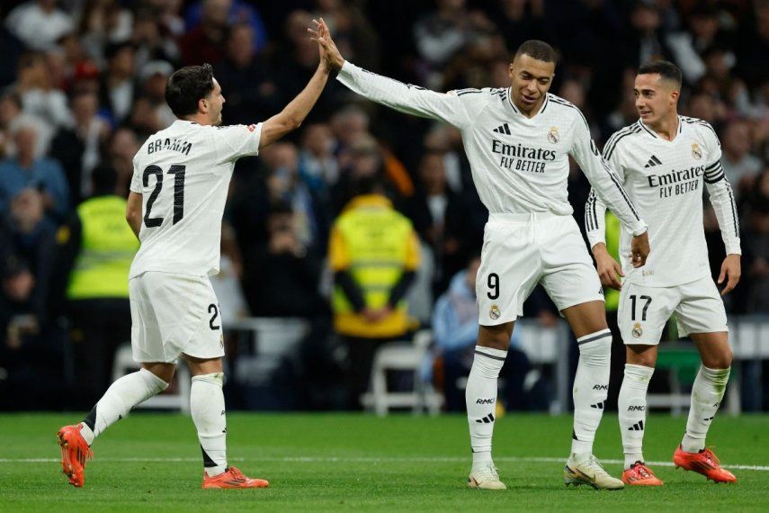 El atacante Brahim Díaz (izquierda), del Real Madrid, celebra junto a su compañero Kylian Mbappé (centro) luego de anotar el cuarto gol de su equipo en un partido contra el Sevilla, el 22 de diciembre de 2024.