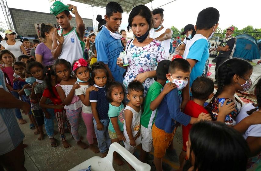 Niños venezolanos que viajan con sus familias hacen fila para jugar en un centro comunitario que se utiliza como refugio en Arauquita, Colombia.