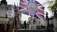 Una bandera con una imagen del rey Carlos III de Gran Bretaña a la venta para celebrar la coronación del rey Carlos III, en una tienda de Londres, el jueves 27 de abril de 2023. Expectación y protestas ante coronación del monarca.