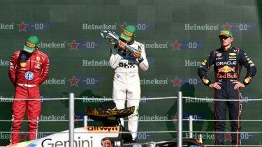 El piloto británico de McLaren, Lando Norris (C), besa el trofeo en el podio junto al piloto monegasco de Ferrari, Charles Leclerc (I), que quedó en segundo lugar, y el piloto holandés de Red Bull Racing, Max Verstappen (D), que quedó en tercer lugar, después de ganar el Gran Premio de Fórmula 1 de la Ciudad de México en el autódromo Hermanos Rodríguez en la Ciudad de México el 26 de octubre de 2025.
