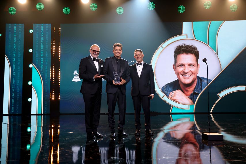 Manuel Abud, director ejecutivo de la Academia Latina de la Grabación, el homenajeado Carlos Vives y Alejandro Sanz posan en el escenario durante la ceremonia de la Persona del Año de la Academia Latina de la Grabación 2024 en el Centro de Convenciones de Miami Beach el 13 de noviembre de 2024 en Miami, Florida.