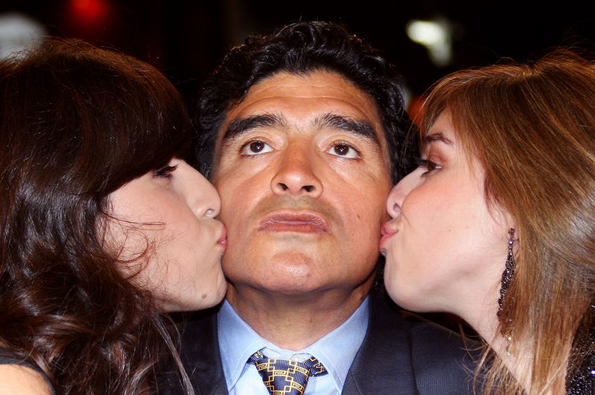 En esta foto de archivo tomada el 20 de mayo de 2008, el ex jugador de fútbol argentino Diego Maradonaes besado por sus hijas Giannina y Dalma