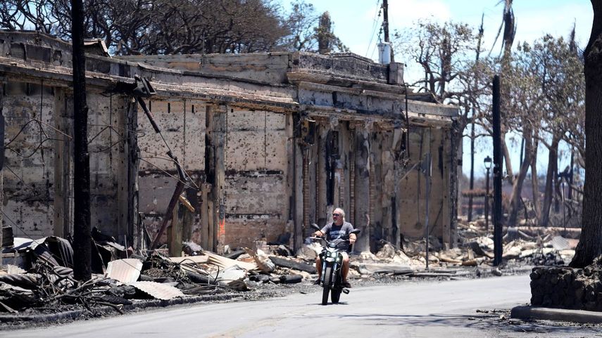 Un hombre circula en motocicleta entre los daños causados por un incendio, el 11 de agosto de 2023, en Lahaina, Hawai.&nbsp;
