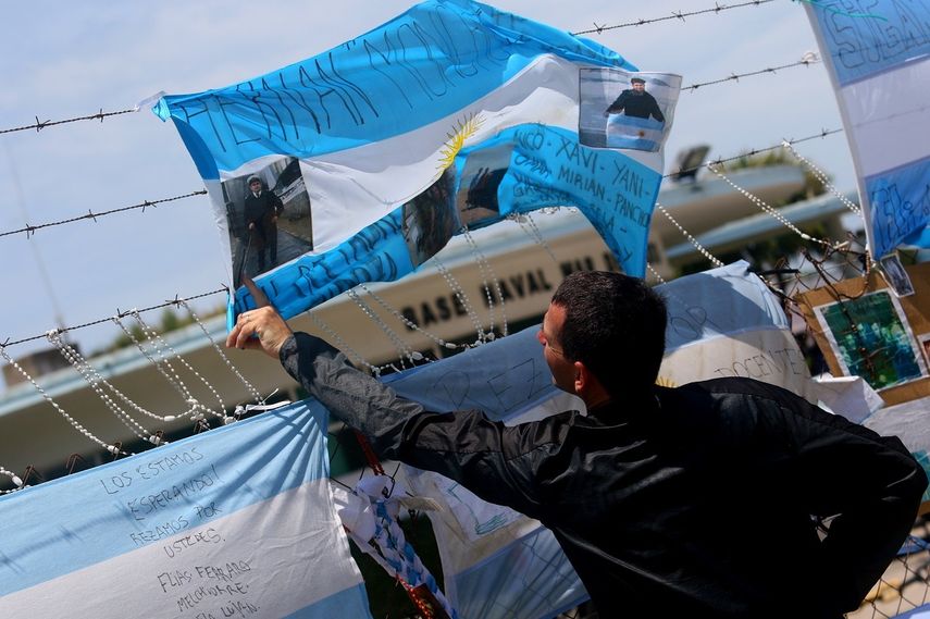Un hombre cuelga una bandera para brindar apoyo a los familiares en la Base Naval Mar del Plata.