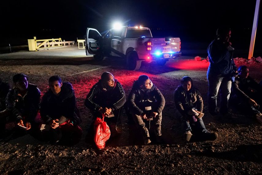 &nbsp;Varios migrantes esperan ser procesados por las autoridades estadounidenses luego de cruzar la frontera de Estados Unidos con México, el 6 de enero de 2023, cerca de Yuma, Arizona.