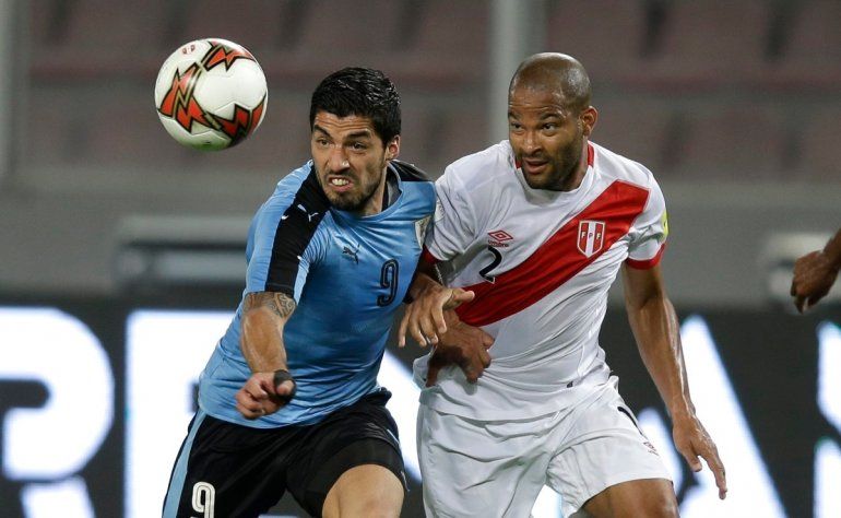 El delantero uruguayo Luis Suárez (izquierda) pugna un balón con el peruano Alberto Rodríguez durante un partido de las eliminatorias de Sudamérica para el Mundial, el 28 de marzo de 2017, en Lima. 