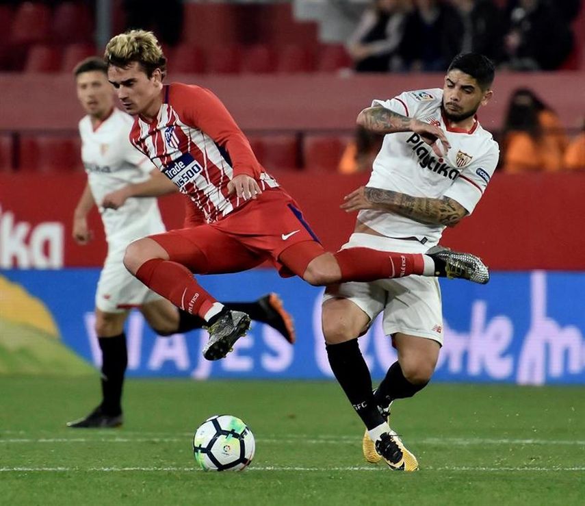 Griezmann (i) supera a Banega, del&nbsp;Sevilla (d), durante el partido ante el Sevilla.