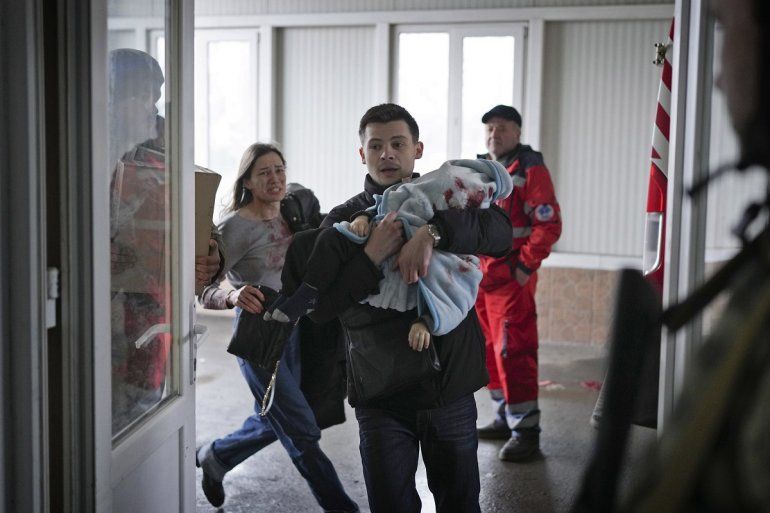 Marina Yatsko, a la izquierda, corre detrás de su novio Fedor con su hijo Kirill, de 18 meses, que murió en un bombardeo, cuando llegan a un hospital en Mariupol, Ucrania, el viernes 4 de marzo de 2022. 