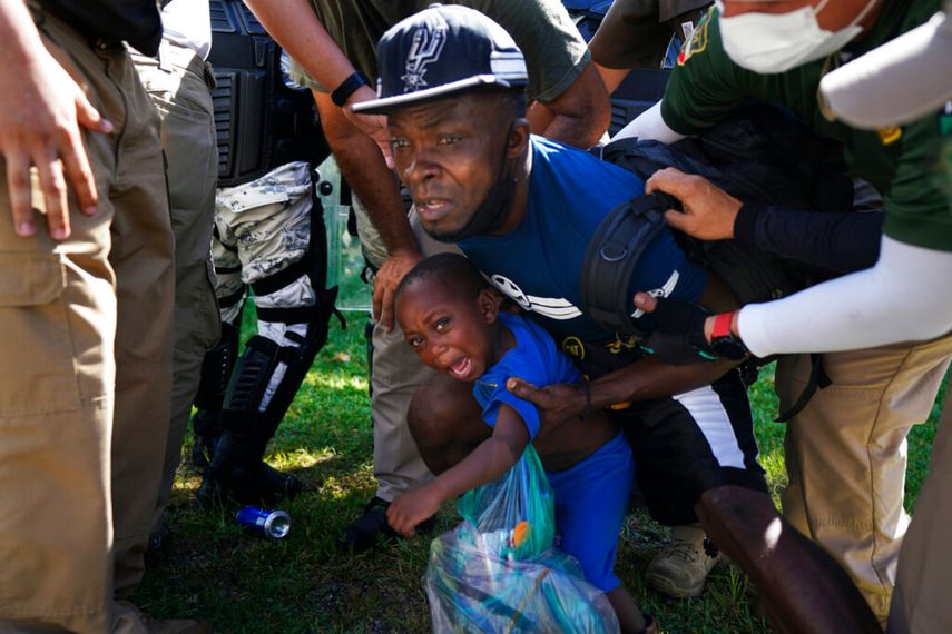 La Guardia Nacional Mexicana detiene a uno de los migrantes haitiano y a su hijo mientras caminaban por una carretera en Escuintla, estado de Chiapas, México, el jueves 2 de septiembre de 2021, en su viaje hacia Estados Unidos.