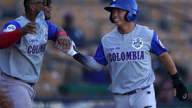 Tsung Che Cheng, de Colombia, es felicitado tras anotar ante Venezuela en un encuentro de la Serie del Caribe, el viernes 28 de enero de 2022, en Santo Domingo&nbsp;
