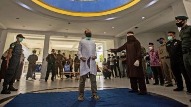 Un funcionario de Sharia emplea un bastón de caña para golpear a un hombre condenado por tener relaciones sexuales homosexuales en Banda Aceh, en la provincia de Aceh, Indonesia, el jueves 28 de enero de 2021