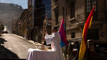 En esta foto de archivo del 11 de junio de 2020, un sacerdote católico viaja en la parte trasera de un vehículo militar durante una procesión que marca el Corpus Christi, que conmemora la transubstanciación bíblica del pan y el vino en el cuerpo y sangre de Cristo, en La Paz, Bolivia. 
