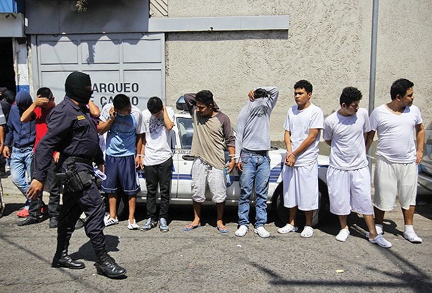 Agentes de la Policía Nacional Civil custodian a pandilleros del Barrio 18 a las afueras de una delegación policial en San Salvador (EFE/Archivo)