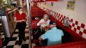 Una empleada de un restaurante atiende a clientes. Una empleada de un restaurante atiende a clientes.